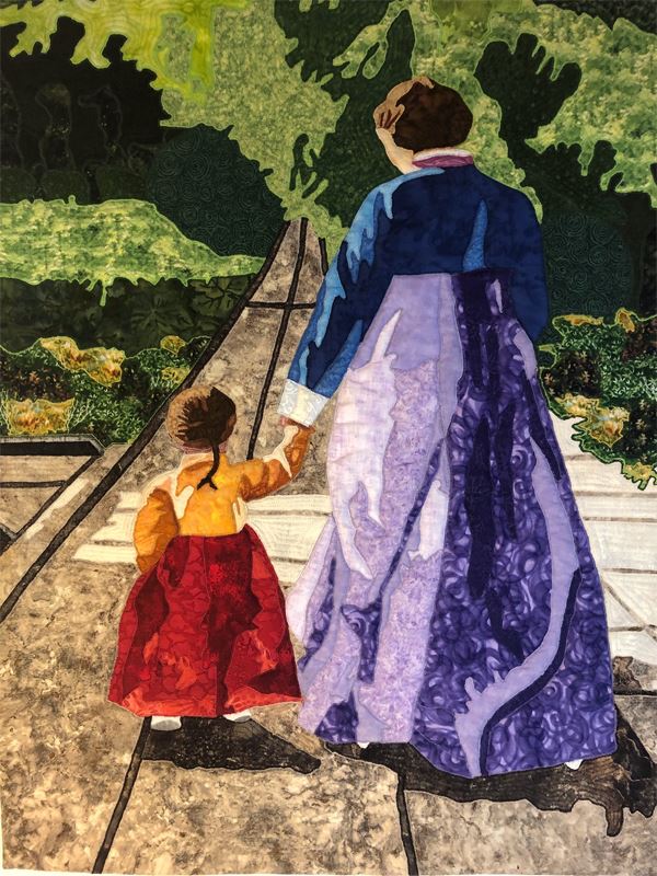A picture of a quilt from the exhibit featuring a woman and child