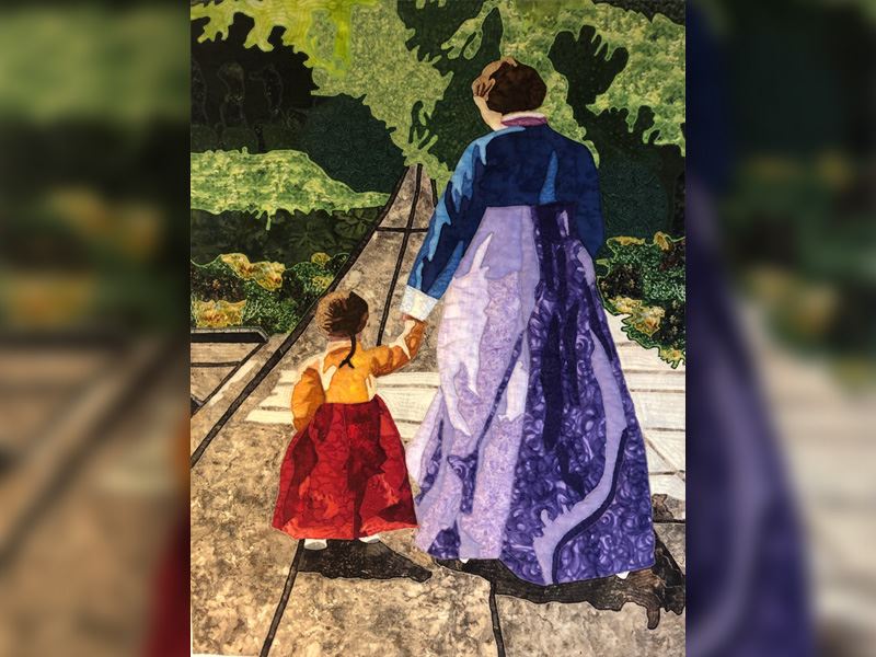 Picture of a quilt with a woman and child